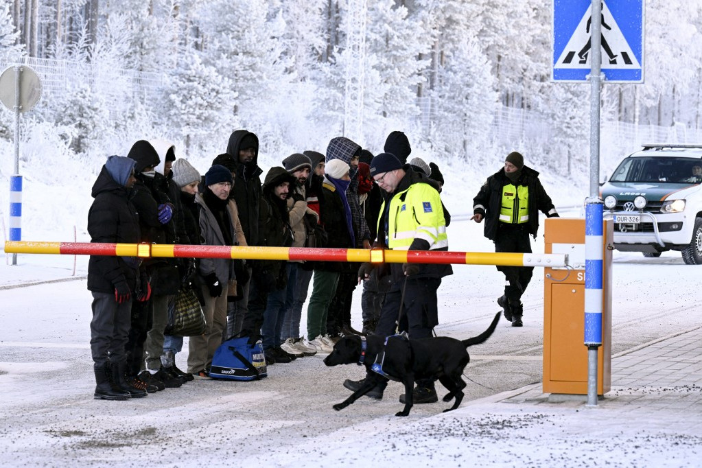 Migránsok és finn határőrök kutyával az észak-finnországi Sallában 2023. november 22-én